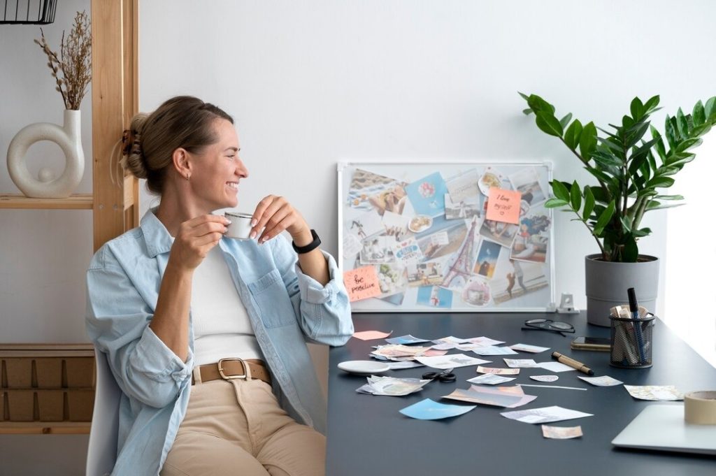A woman sitting at a desk with a laptop, surrounded by colorful post-it notes, focused on her work